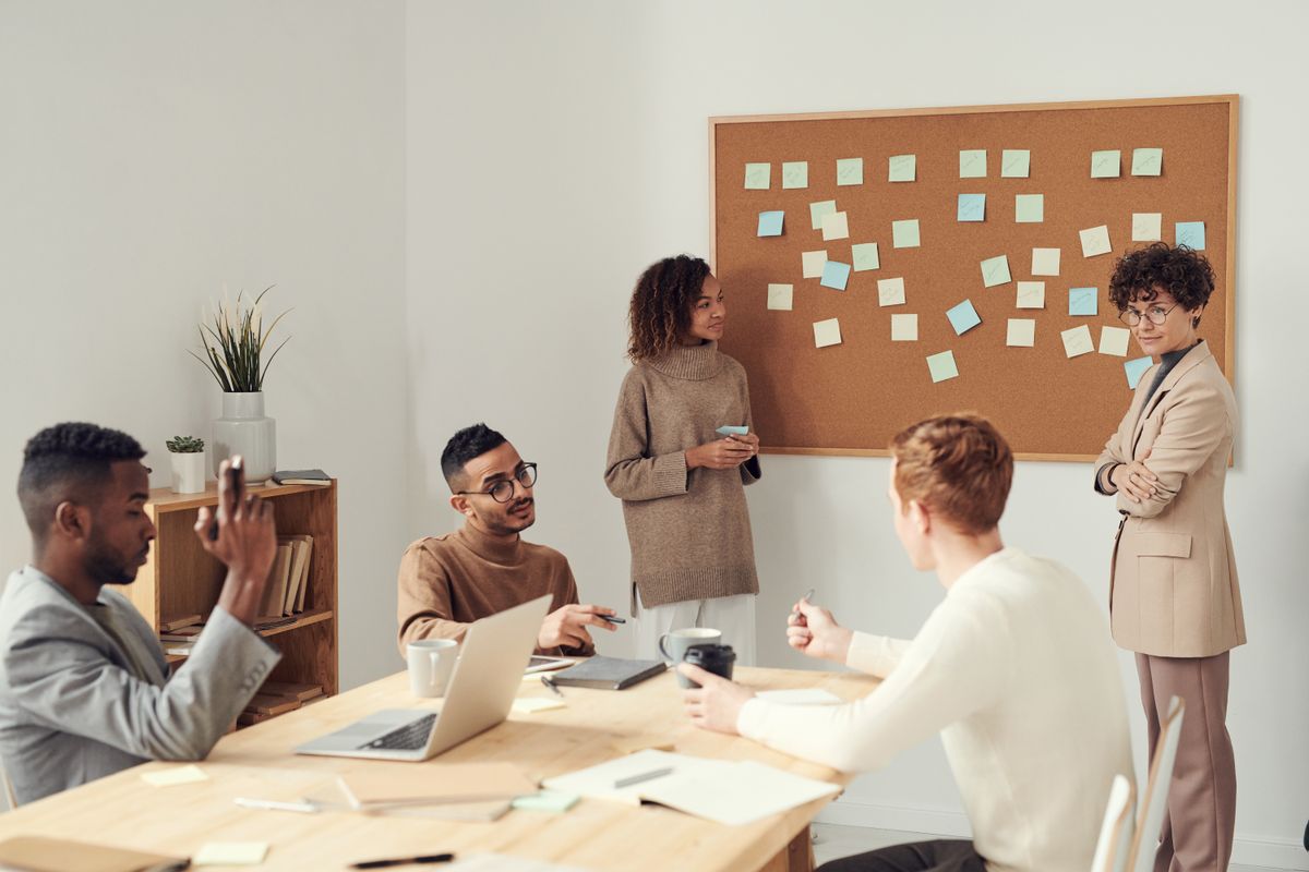 A team collaborating around a table in front of a planning board